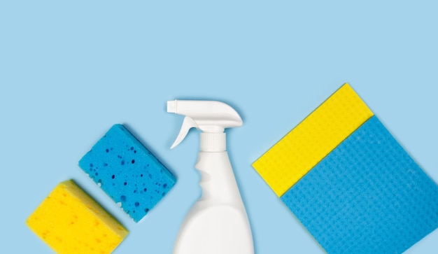 cleaning products on a blue background top view copy space