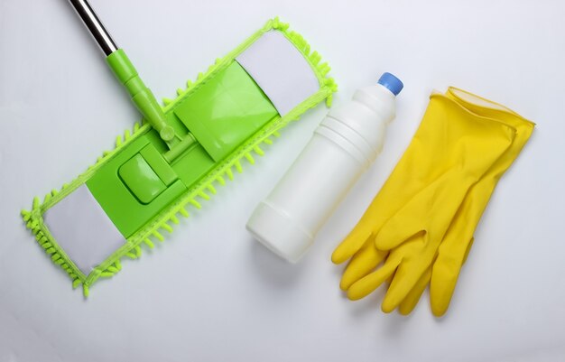 청소 도구. 플라스틱 녹색 걸레, 장갑, 흰색 표면에 세제 병. 집안에서 소독 및 청소. 평면도