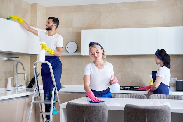Cleaning service team at work in kitchen in private home