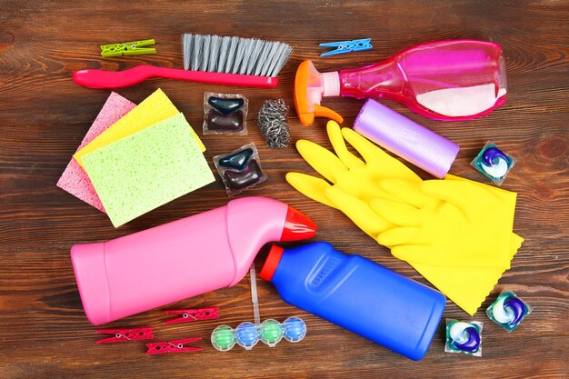 Cleaning set with tools and products on wooden background