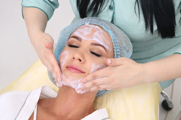 Cleaning the skin with foam, a beautiful woman in the beauty salon beauty