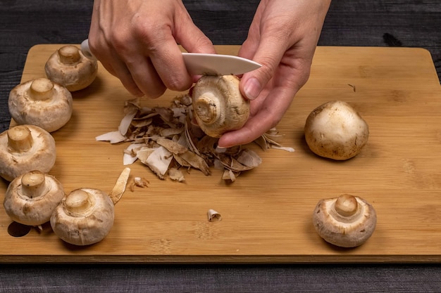 Cleaning and slicing mushrooms as part of the process of preparing fresh champignons for subsequent freezing