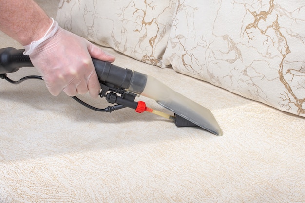 Cleaning the sofa with a vacuum cleaner