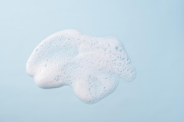 Photo cleaning sponge and a soapy foam on a blue background