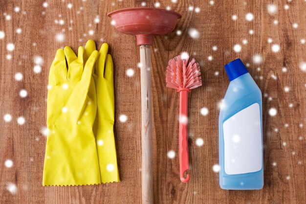 Foto cose di pulizia lavori domestici pulizia e concetto domestico pistone guanti di gomma e spazzola da bagno con detergente su sfondo di legno su neve