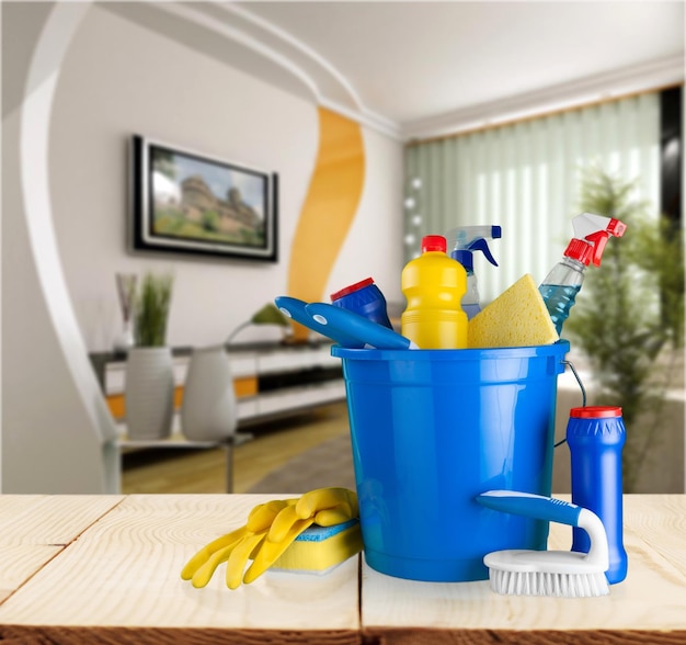 Cleaning supplies in bucket on background