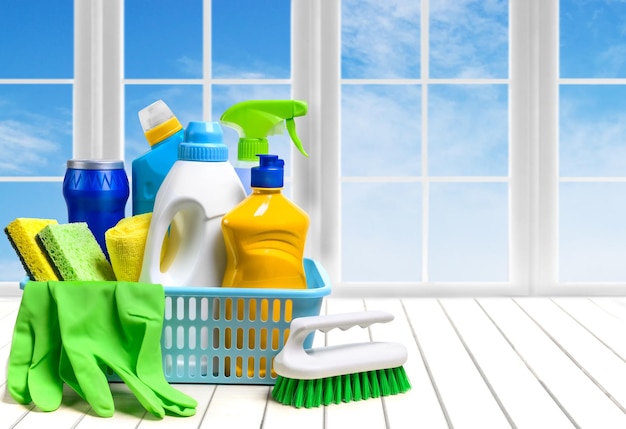 Cleaning supplies in plastic box on the window and sky background