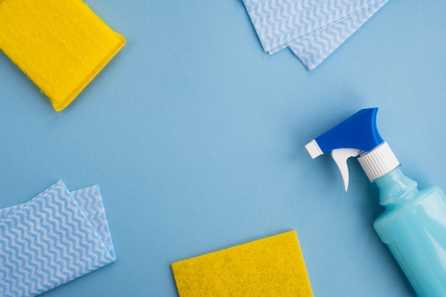 Cleaning supplies and sponges on light blue background. Spring cleaning