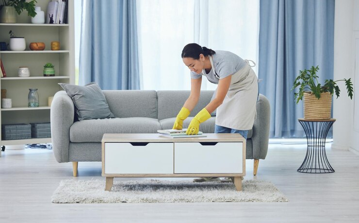 Photo cleaning tidy and woman by table in living room for organising remove dirt or doing chores magazine gloves and domestic worker with apron for housekeeping maid service or maintenance in home