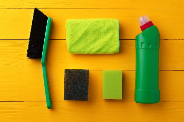 Cleaning tools composition flat lay on yellow wooden background