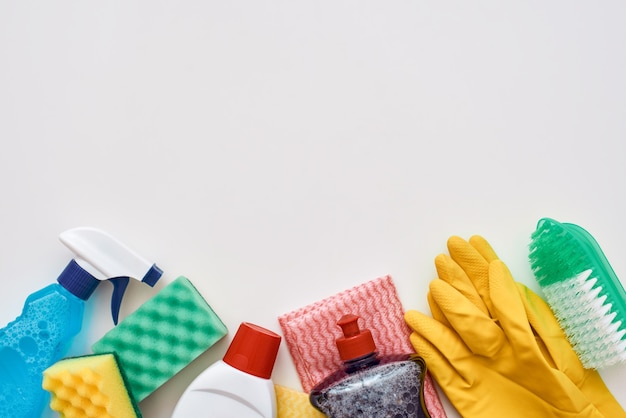 Cleaning tools. Spray bottle, orange cleaner sponge and cleanser isolated at the bottom of the picture. Cropped photo