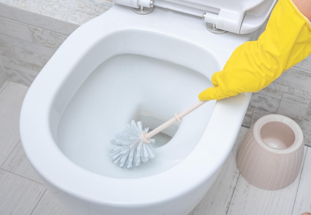 Cleaning wc Housekeeper cleaning man at toilet Brush up Toilet for cleanliness and hygiene cleaning toilet bowl Cleaning service concept