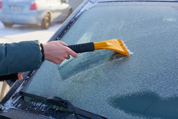 車のフロントガラスを氷から掃除する