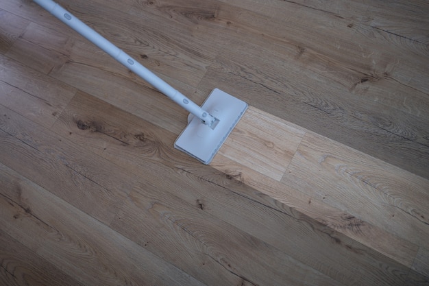 Cleaning wood floor with mop over view