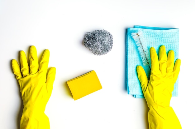 Photo cleanliness and cleaning rag sponge and brush females hands in yellow gloves