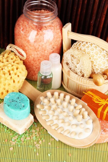 Cleanser brush and cosmetics for shower on table on bamboo background