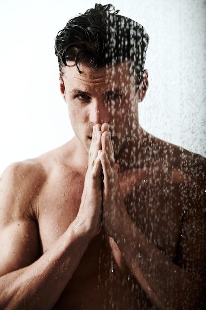 Photo cleansing his body and his mind shot of a handsome man taking a shower