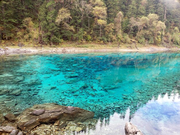 Photo a clear blue lake with a mountain in the background