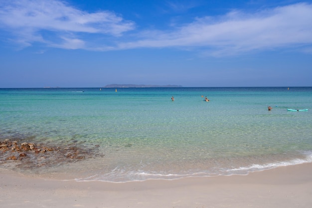 Clear blue sea beach with small calm wave island rocks on beach clear blue sky