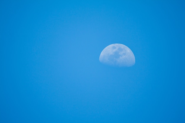 Clear blue sky with half moon