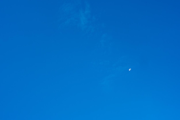 A clear blue sky with a moon in it