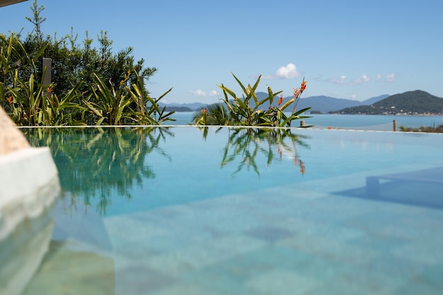 clear blue water by the pool relaxing at the beach house on a sunny day with blue sky