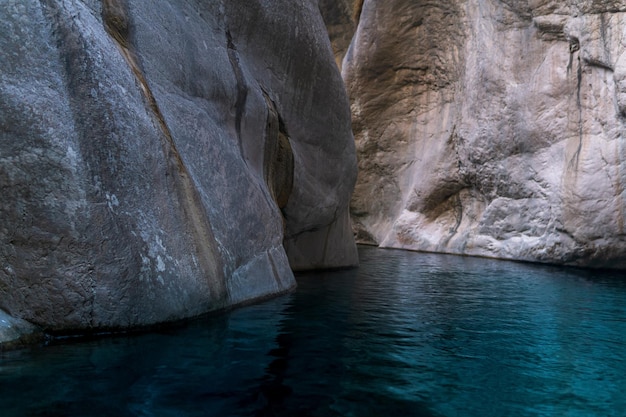 Clear blue water in a deep canyon with sheer rock walls