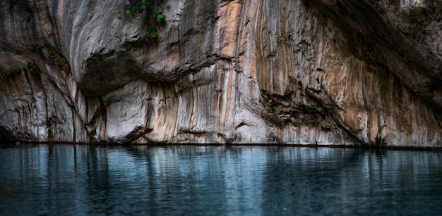 Clear blue water in a deep canyon with sheer rock walls