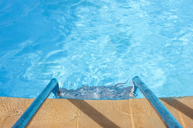 Acqua blu chiaro e una scala in piscina