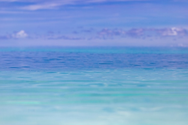 Clear sky and calm sea or ocean water surface on blurred background with shallow depth of field. Art