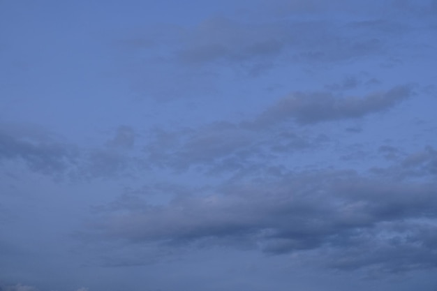 A clear sky with a few clouds and a moon in the sky.