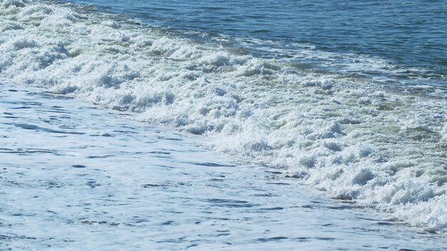 Photo clear summer day over a calm sea coast with large pebble slow motion