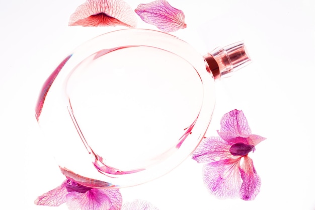 Foto trasparente trasparente profumo o bottiglia di aroma con fiori profumo donna orchidea su sfondo bianco con orchidea