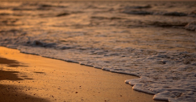 A clear transparent sea wave rolls over a rocky pebble beach the concept of rest and travel