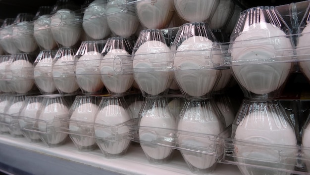 Clear trays of eggs on the refrigerated shelf at grocery shop