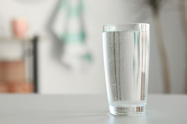 Photo clear water in a glass and bottle on the table