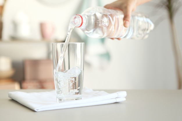 Clear water in a glass and bottle on the table