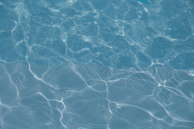 Clear water surface in swimming pool with blue tiles. modern\
minimalist architecture. wavy water.