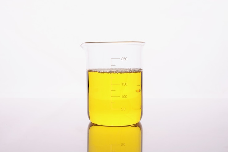 Photo clear yellow liquid is poured into beaker