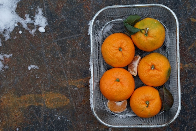 Clementines tangerines  as Christmas decor over snow background.