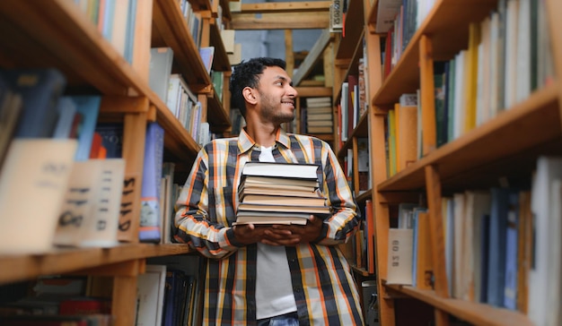図書館でスタイリッシュなカジュアルな服を着た賢いアラビア人またはインド人の男子学生またはフリーランサー