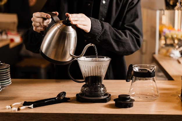 Clever coffee dripper and pour over filter coffee alternative brewing method Pouring hot water over roasted and ground coffee beans contained in paper filter