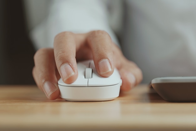 Click white computer mouse on a work desk Working with a PC or laptop