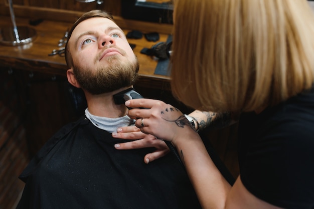 Client during beard shaving in barber shop