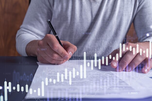 A Client In Casual Wear Is Signing The Contract To Invest Money In Stock Market Internet Trading And Wealth Management Concept Forex And Financial Hologram Chart Over The Desk