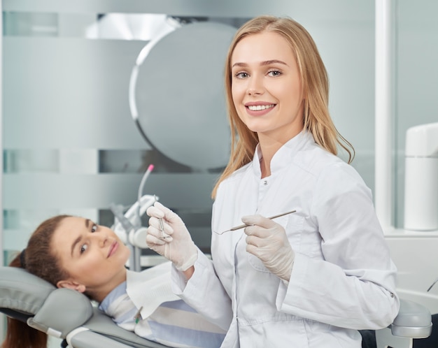 Client of dentistry clinic and dentist posing.