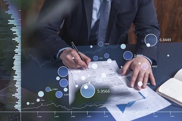 A client in formal wear is signing the contract to invest money in stock market Internet trading and wealth management concept Forex and financial hologram chart over the desk