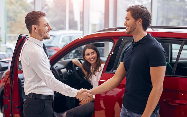 Client and manager making agreement in car dealership