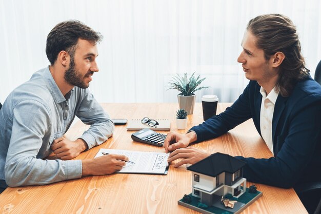 Foto il cliente e l'agente immobiliare rivedono il contratto di prestito e discutono del termine entità