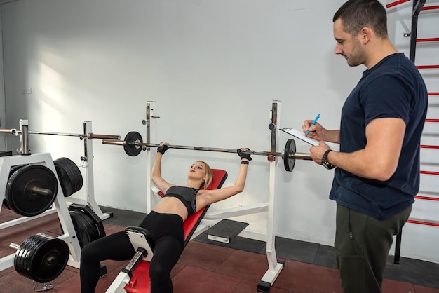 Client with poersonal trainer doing workout exercise at gym abdominal crunches